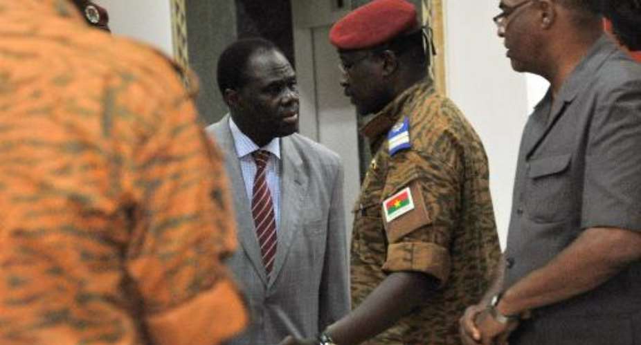 Burkina Faso's interim President Michel Kafando C speaks with newly appointed Prime Minister Lieutenant Colonel Isaac Zida 2nd R at the presidential palace in Ouagadougou on November 19, 2014.  By Sia Kambou AFP