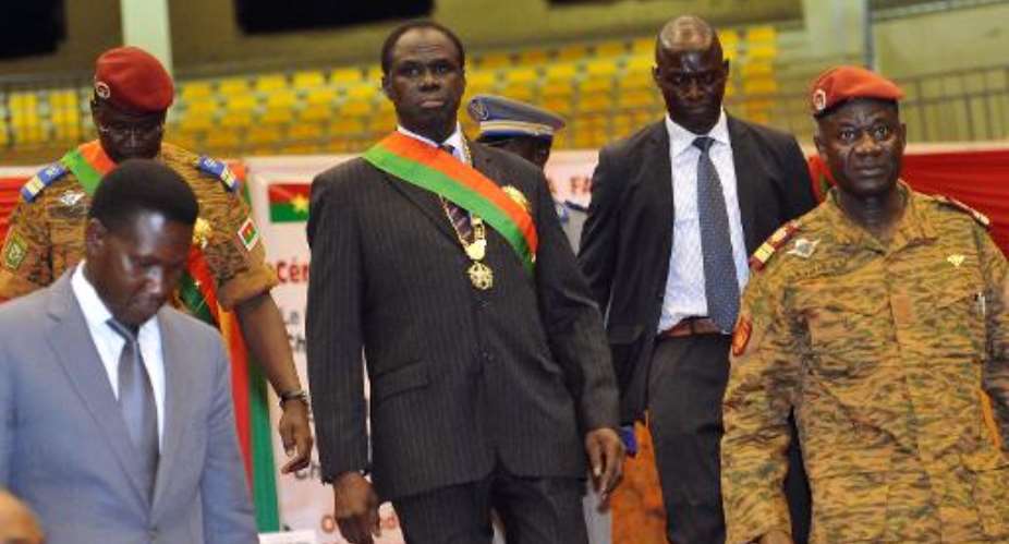 Burkina Faso's Interim President Michel Kafando C leaves with Prime Minister Lt. Col. Isaac Zida 2ndL after his inauguration ceremony in Ouagadougou on November 21, 2014.  By Sia Kambou AFPFile
