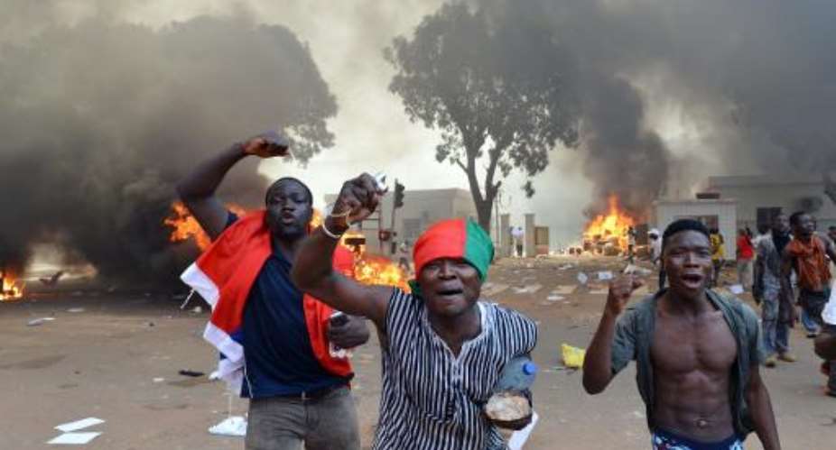 Cars burn outside Burkina Faso's parliament in Ouagadougou on October 30, 2014.  By Issouf Sanogo AFP