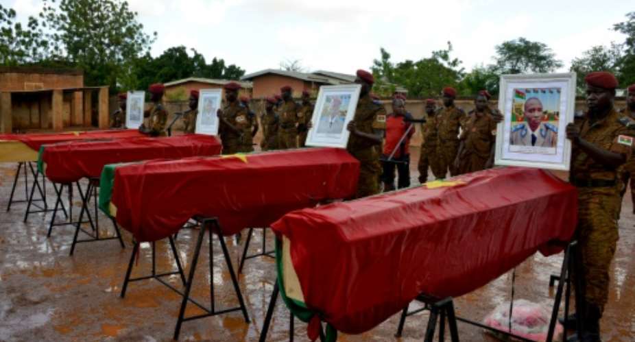 Burkinabe soldiers stand at the coffins of their comrades killed near the Mali border.  By AHMED OUOBA AFPFile