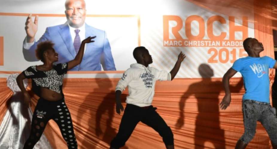 Artists perform in front of a banner of Burkina Faso's new president Roch Marc Kabore during a victory celebration in Ouagadougou on December 1, 2015.  By Issouf Sanogo AFP