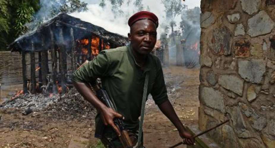 A Burundian soldier runs from a house set on fire by protesters in Butagazwa, some 30 kms east of the capital Bujumbura, on June 5, 2015.  By Carl De Souza AFPFile