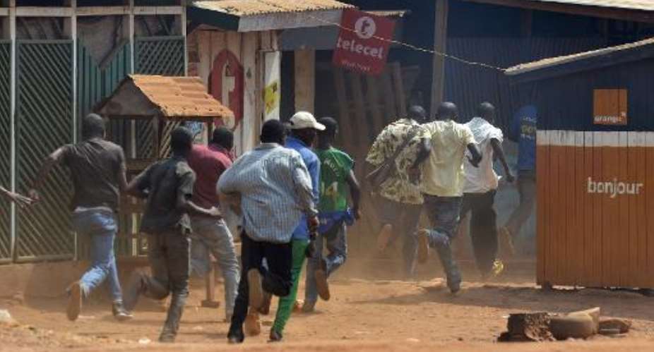 Men run during a protest against the French Sangaris intervention in the Galabadia neighbourhood of Bangui on December 22, 2013.  By Miguel Medina AFP
