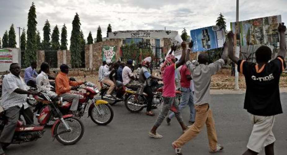 Protestors walk past the headquarters of the ruling party, the CNDD-FDD, on May 24, 2015 in Bujumbura.  By Carl de Souza AFP