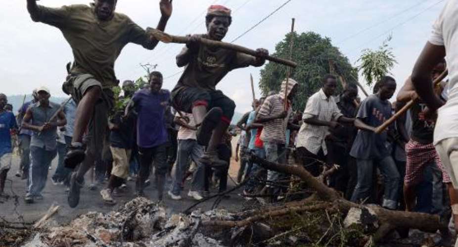 Burundian youths jump over a burning baricade as they demonstrate in Bujumbura, on May 1, 2015.  By Simon Maina AFPFile