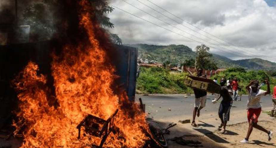 People burn mattresses looted from the local police post in Bujumbura during a protest against incumbent President Pierre Nkurunziza's bid for a thrd term, on May 13, 2015.  By Jennifer Huxta AFPFile