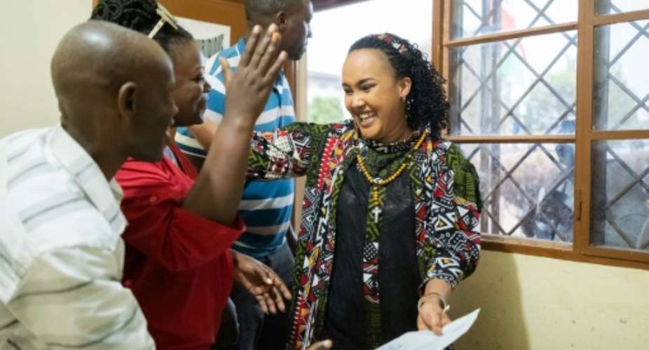 Burundian journalist Floriane Irangabiye greets her legal team after walking out of the Bubanza prison.  By Tchandrou NITANGA (AFP)