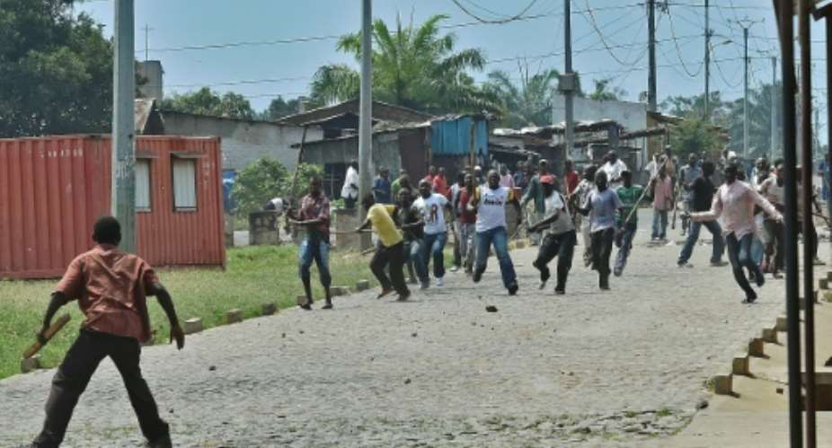 Burundi's oppositions says the ruling party's ferocious Imbonerakure youth wing, seen here poised to attack a demonstrator in 2015, have been forcing people to enrol ahead of a constitutional referendum in May.  By CARL DE SOUZA AFPFile