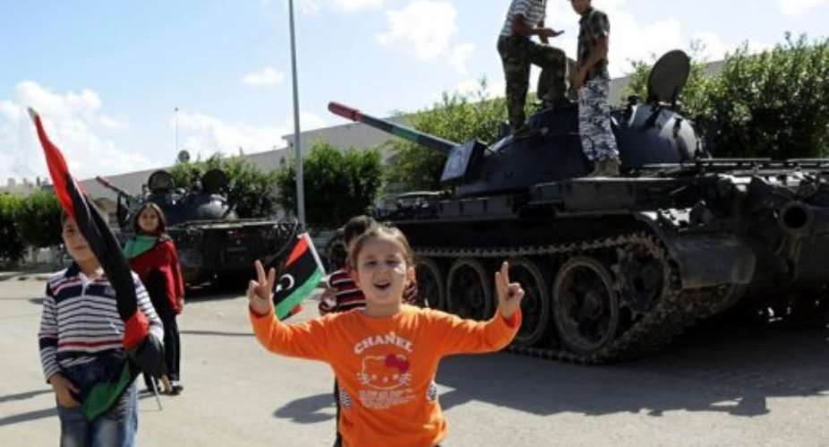 A young Libyan girl flashes the V-for-victory sign during a celebration in honour of NTC fighters on October 28.  By Philippe Desmazes (AFP/File)