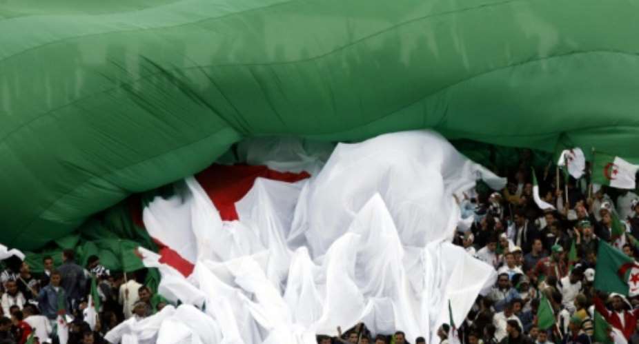 Fans of Algerian team Entente Setif hold a national flag as they cheer their team on May 3, 2007 in Setif.  By Fayez Nureldine AFPFile