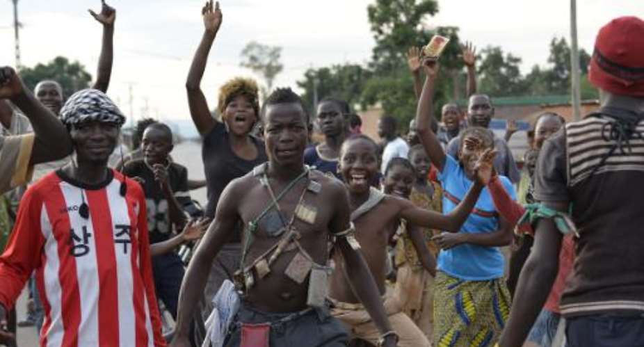 Bangui residents celebrate after a convoy of Chadian soldiers leave Bangui on April 4, 2014.  By Miguel Medina AFPFile