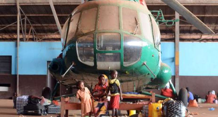A family gathers near a helicopter in a hangar at the airport in Bangui on January 30, 2014.  By Issouf Sanogo AFP
