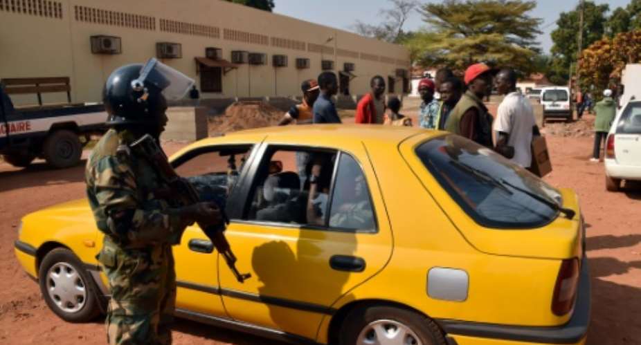 A Central African Republic police officer talks with a taxi driver outside a vote-counting centre for the presidential and parliamentary elections on January 2, 2016 in Bangui.  By Issouf Sanogo AFPFile
