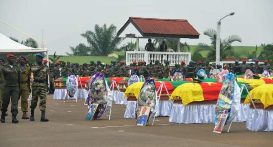 Cameroonian soldiers march around coffins during a ceremony for 38 soldiers who died in the north of the country while fighting Islamist Boko Haram militants, at the military headquarters in Yaounde on March 6, 2015.  By Reinnier Kaze (AFP)