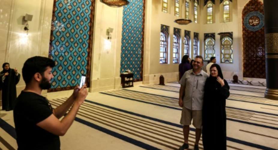 Canadian couple Dorinel and Clara Popa pose for a picture inside Doha's Blue Mosque.  By MAHMUD HAMS AFP