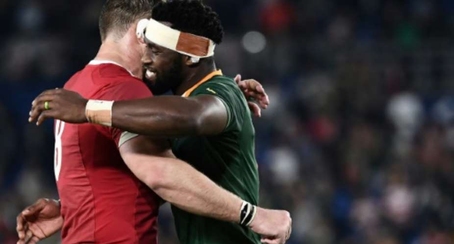 Captain Siya Kolisi R hugs teammate Duane Vermeulen, wearing a Wales shirt, after a 19-16 World Cup semi-final victory last Sunday.  By Anne-Christine POUJOULAT AFP