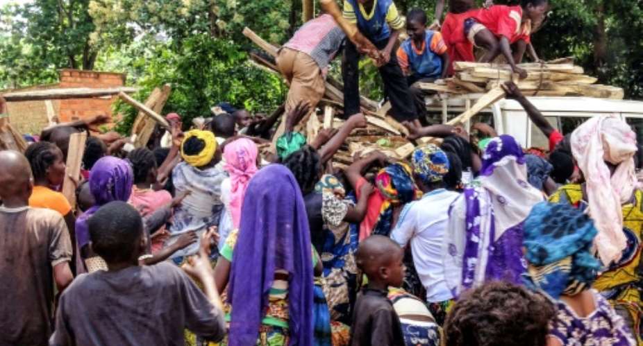 Central African internal-displaced people gather around a truck where volunteers distribute fire wood in Bangassou. At least 108 people were slaughtered and 76 injured during an attack by several hundred fighters on the town on May 13.  By SABER JENDOUBI AFP