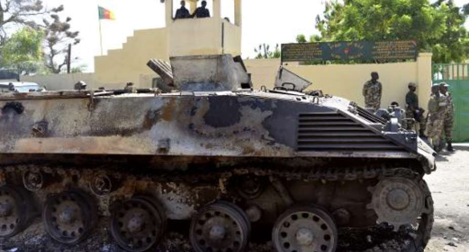 A Boko Haram' tank destroyed by Cameroonian soldiers stands in front of a military base in Amchide, northern Cameroon on October 15, 2014.  By Reinnier Kaze AFPFile