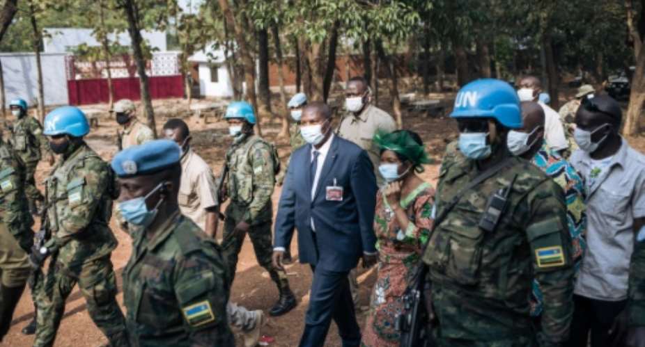 Central African Republic President Faustin Archange Touadera, centre, protected by Rwandan UN peacekeepers on election day last December.  By ALEXIS HUGUET AFP