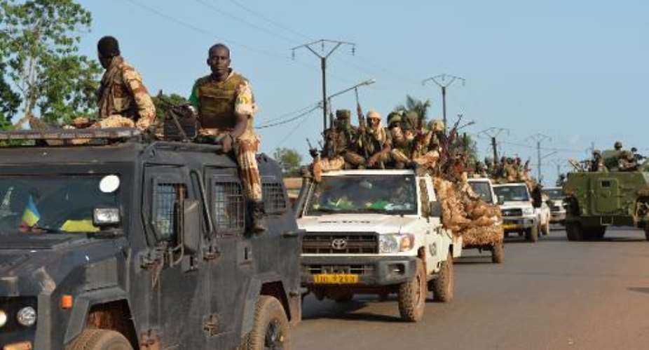 Chadian soldiers sit on a pickup truck as they leave Bangui on April 4, 2014, escorted by African-led MISCA forces.  By Miguel Medina AFP