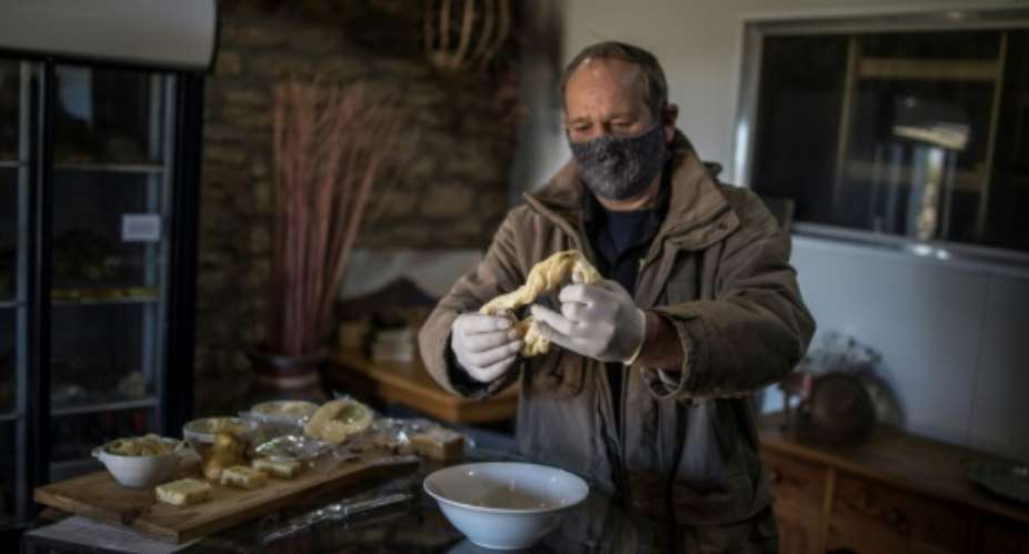 Cheesemakers Danie Crowther and his wife Marietjie Crowther only managed to produce small amounts of their signature smoked mozzarella and chilli-infused string cheese during the virus lockdown.  By MARCO LONGARI AFP
