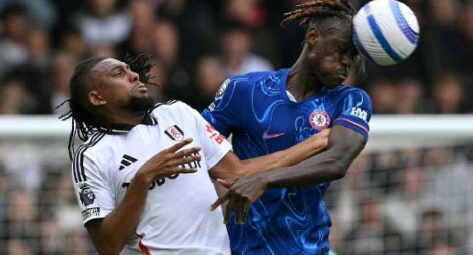 Chelsea defender Trevoh Chalobah (R) wins an aerial duel against Fulham midfielder Alex Iwobi.  By Glyn KIRK (AFP)