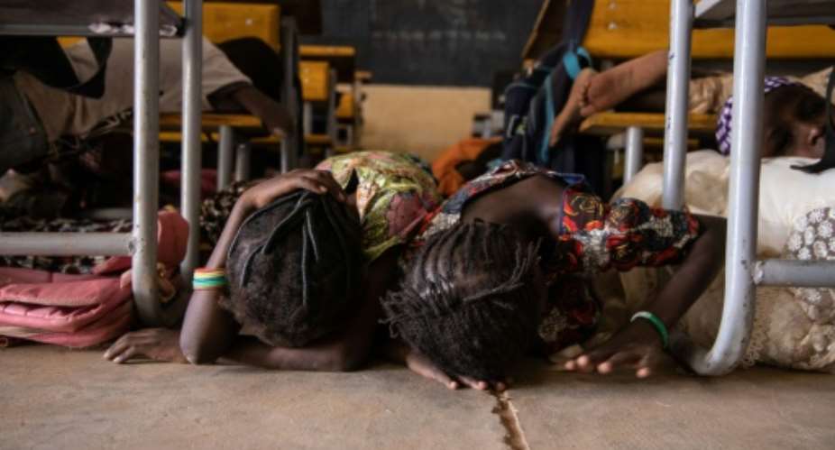Children hide on the ground during a drill for potential attacks in Burkina Faso, where such assaults have shuttered 3,500 schools.  By OLYMPIA DE MAISMONT AFP