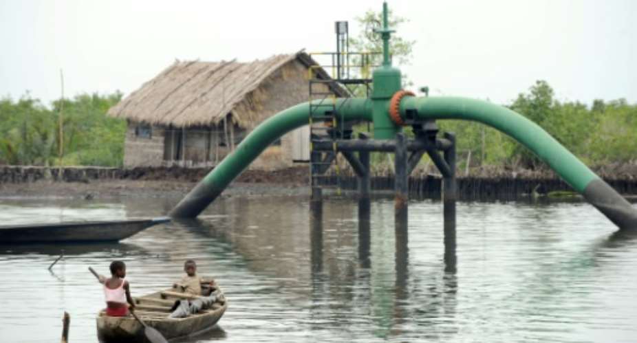 Children paddle past an oil pipeline head near their home in the Andoni settlement on Bonny waterways, in Nigeria's southern Rivers state on April 12, 2011.  By Pius UTOMI EKPEI AFPFile
