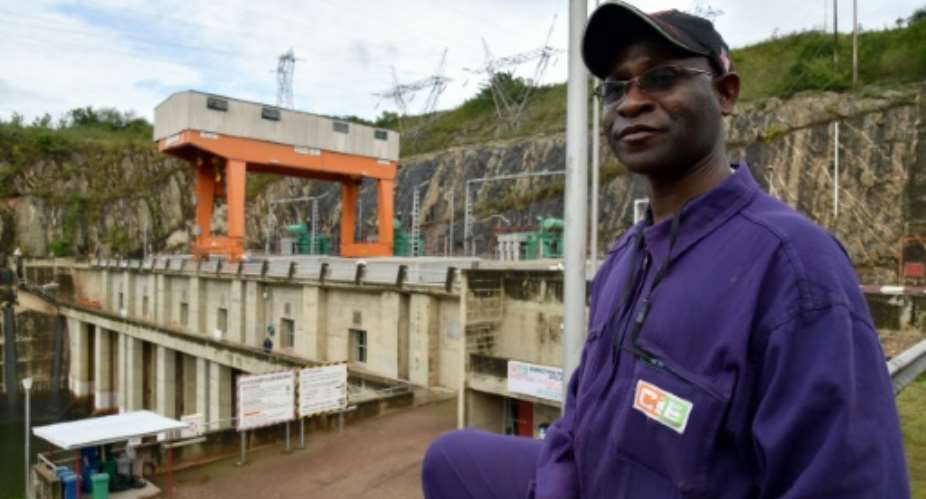 An employee of the Ivorian Electricity Company poses in front of the Kossou dam on September 30, 2014.  By Issouf Sanogo AFPFile