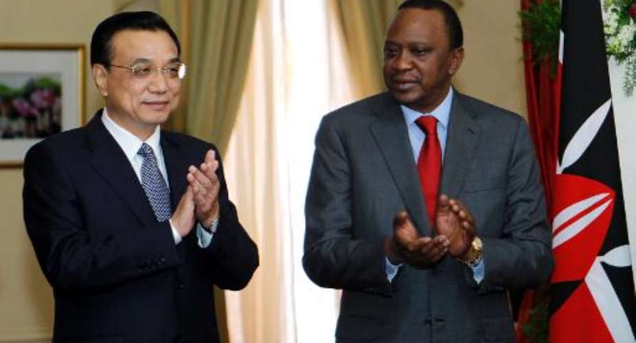 Chinese Premier Li Keqiang left and Kenya's President Uhuru Kenyatta applaud the signing of the Standard Gauge Railway agreement at the State House in Nairobi on May 11, 2014.  By Pool POOLAFP