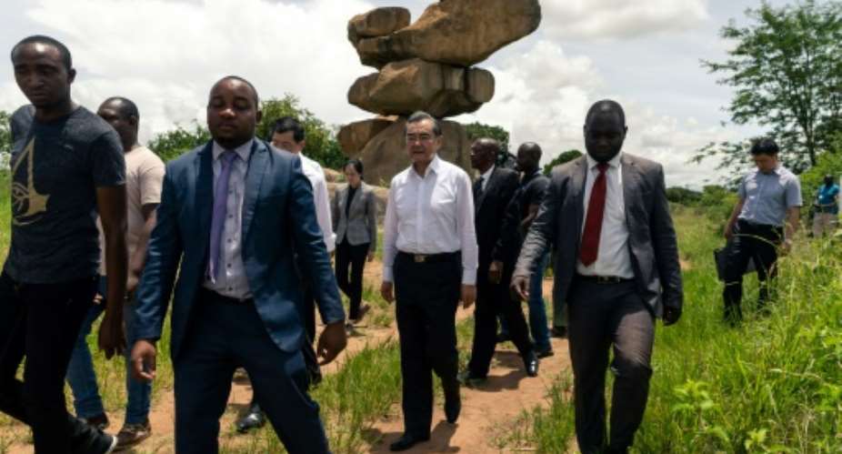 Chinese Foreign Affairs Minister Wang Yi C visits the Epworth Balancing Rocks national park in Harare on a visit to Zimbabwe for talks with leaders.  By Jekesai NJIKIZANA AFP