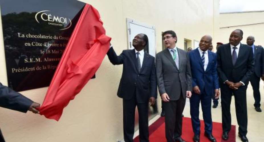 President of the Ivory Coast Alassane Ouattara C, CEO of French chocolate manufacturers Cmoi Patrick Poirrier 2-L unveil a plaque during the innauguration of a CEMOI factory in Abidjan on May 18, 2015.  By Issouf Sanogo AFP