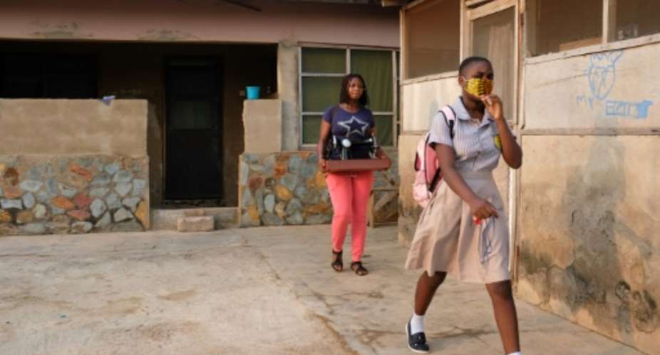Cindy Anyetei, 13, heads out for her school in Accra. Classes were shut for 10 months because of coronavirus..  By Nipah Dennis AFP