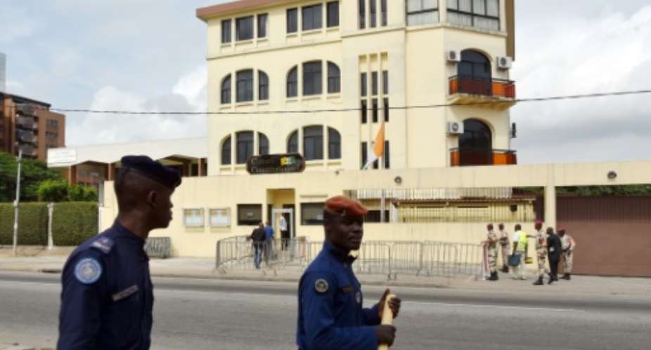 Security personnel walk past the Constitutional Council building on September 9, 2015, in Abidjan.  By Sia Kambou AFPFile