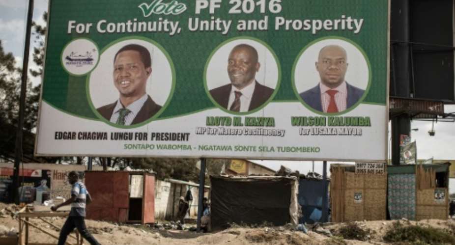 People walk by a billboard with picture of the incumbent president Edgar Lungu, of the Patriotic Front ruling Party, two days ahead of Zambian Presidential and legislative elections on August 9, 2016.  By Gianluigi Guercia (AFP)