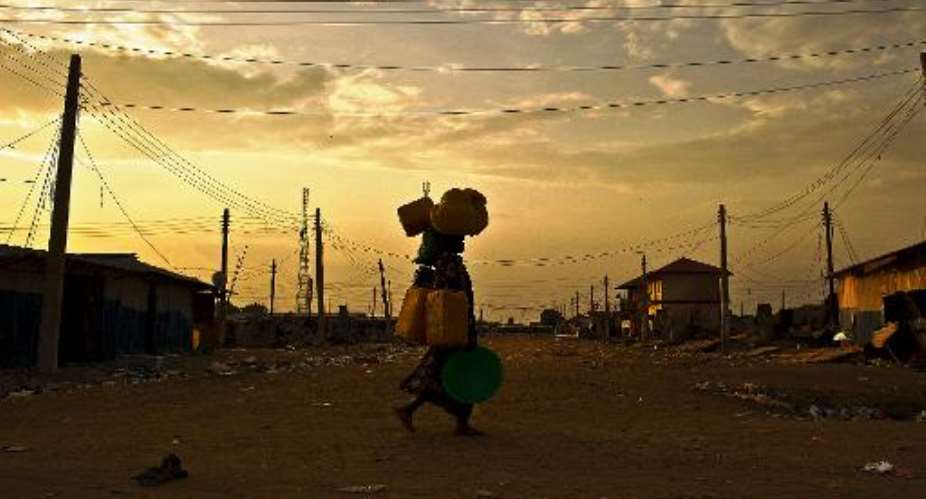 A woman carries belongings through a deserted street in Bor, South Sudan on February 1, 2014.  By Carl de Souza AFPFile