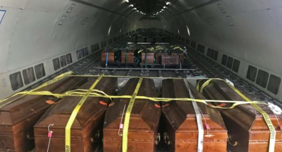 Coffins containing the remains of 20 Egyptian Coptic Christians beheaded by jihadists on the beach in Sirte in 2015 are loaded onto a plane in Misrata on May 14, 2018, before being sent to Cairo.  By MAHMUD TURKIA AFP