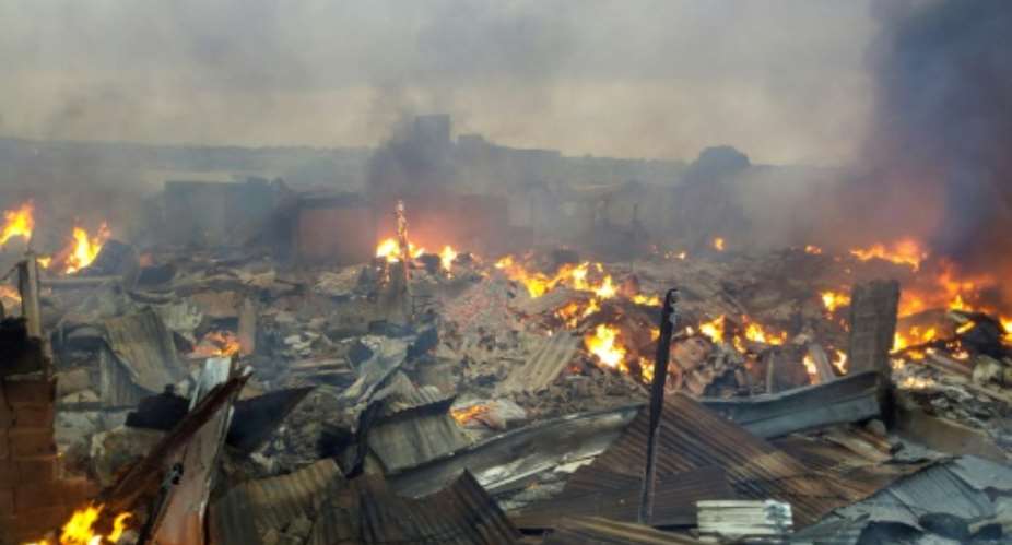 Collapsed stalls burned in the market in Bouake a day after fire broke out in the night.  By - AFP