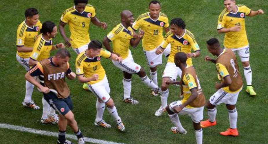 Colombia's players dance as they celebrate scoring during a Group C football match between Colombia and Ivory Coast at the Mane Garrincha National Stadium in Brasilia during the 2014 FIFA World Cup on June 19, 2014.  By Evaristo Sa AFP