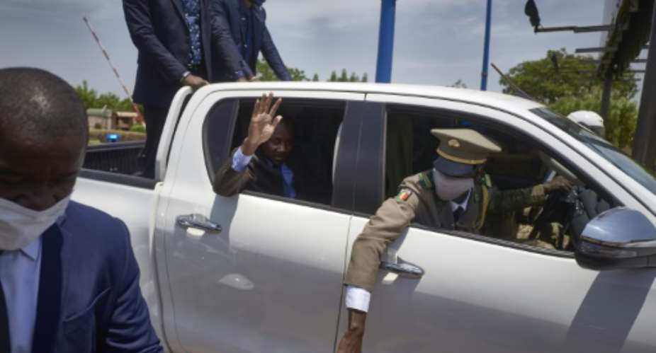Colonel Assimi Goita -- seen waving at supporters from the back of his car -- faces mounting pressure to transition to civilian rule.  By Michele Cattani AFP
