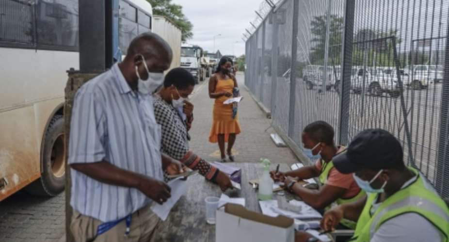 Commuters get COVID-19  test results checked at the South African side of the border -- but a surge in cases is overwhelming authorities on both sides.  By Guillem Sartorio AFP