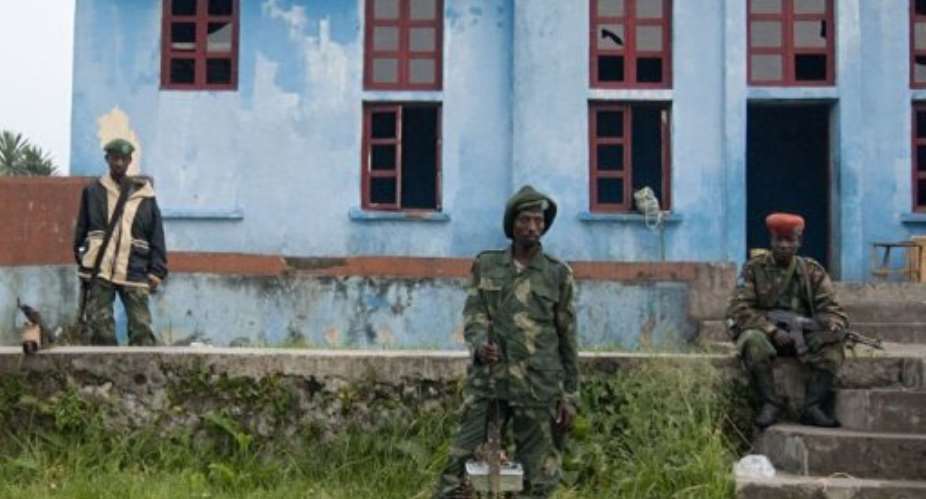 M23 rebel soldiers stand guard at a FARDC base in Rumangabo.  By Michele Sibiloni (AFP)