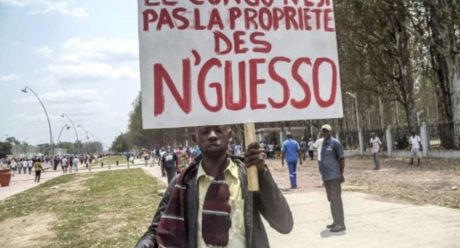 A man holds a placard reading Congo is not the property of Nguesso during an opposition demonstration in Brazzaville on September 27, 2015.  By Laudes Martial Mbon AFPFile