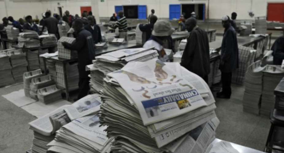 Copies of the China Daily fresh off the printing press pile up before distribution in the Kenyan capital, Nairobi, in this January 3, 2013 file picture.  By TONY KARUMBA AFPFile