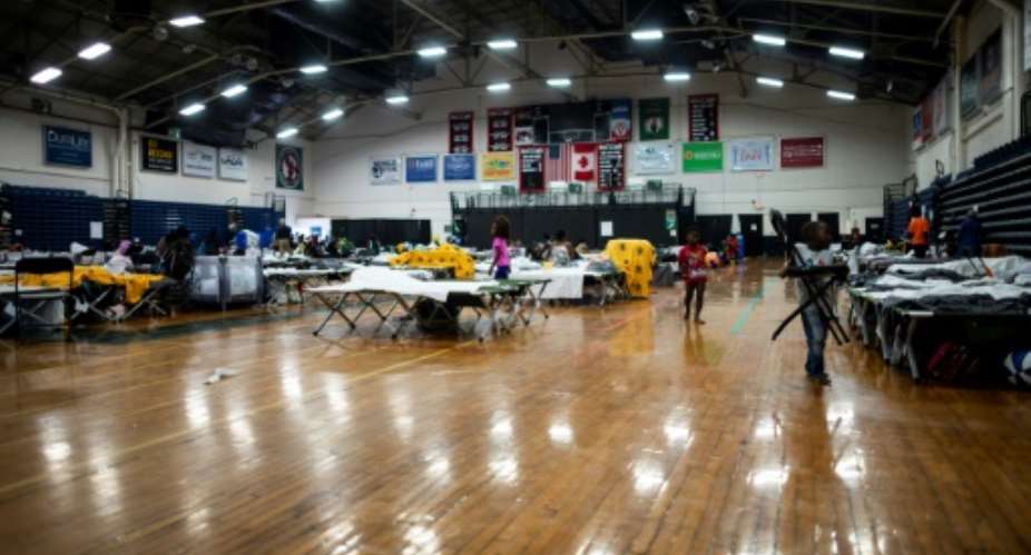 Cots are set up for migrants in The Expo, a sports complex converted into an emergency shelter, in Portland, Maine -- hundreds of Africans have turned the city into an unlikely sanctuary.  By Johannes EISELE AFP