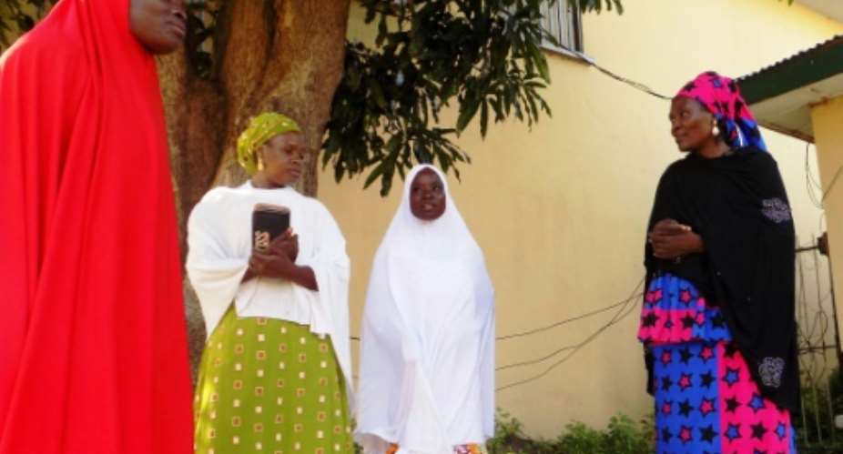 Councillors speak to Hafsat Ibrahim L and Fatima Salisu 2-R, who were held captive for over 12 months and forcibly married to Boko Haram Islamists.  By Aminu Abubakar AFP