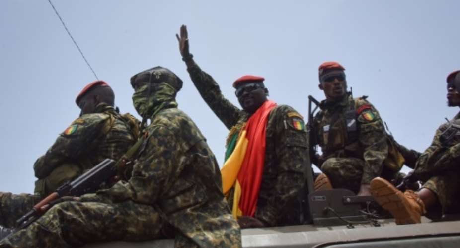 Coup leader Lieutenant Colonel Mamady Doumbouya C waves to the crowd as he arrives at the Palace of the People in Conakry.  By CELLOU BINANI AFP