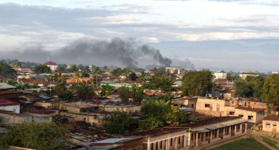 Smoke rises from several buildings near the port in Bujumbura on May 14, 2015 after a night marked by gunfire and explosions in various areas of the capital.  By Jennifer Huxta AFP