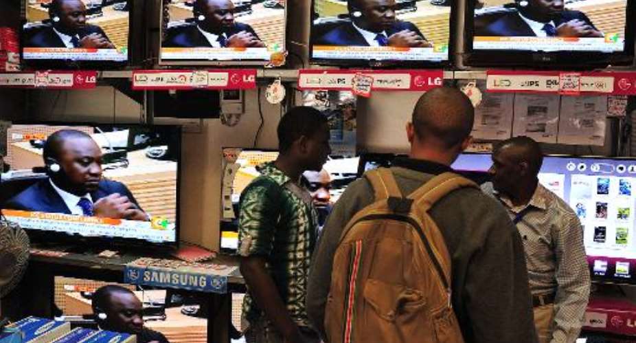 People in Nairobi watch on TV Kenya's president Uhuru Kenyatta appearing in the International Criminal Court ICC in The Hague, on October 8, 2014.  By Simon Maina AFP