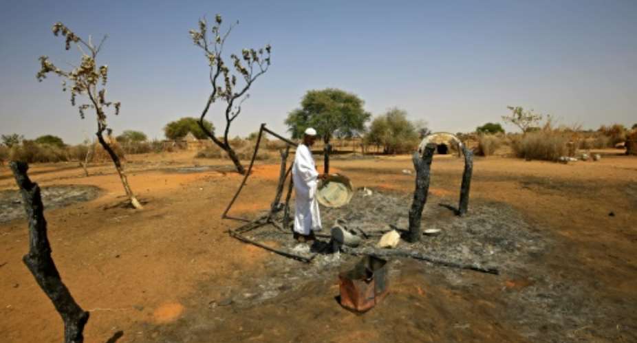 Darfur has seen repeated bouts of violence despite a peace deal last year: here a man visits his home following fighting in February.  By ASHRAF SHAZLY AFP